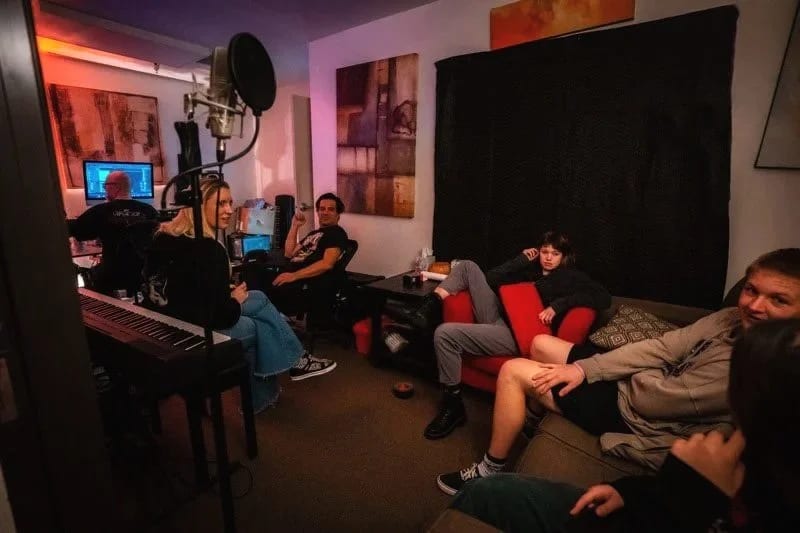 Let There Be Rock School students sitting in the control room of the school's recording studio during a session