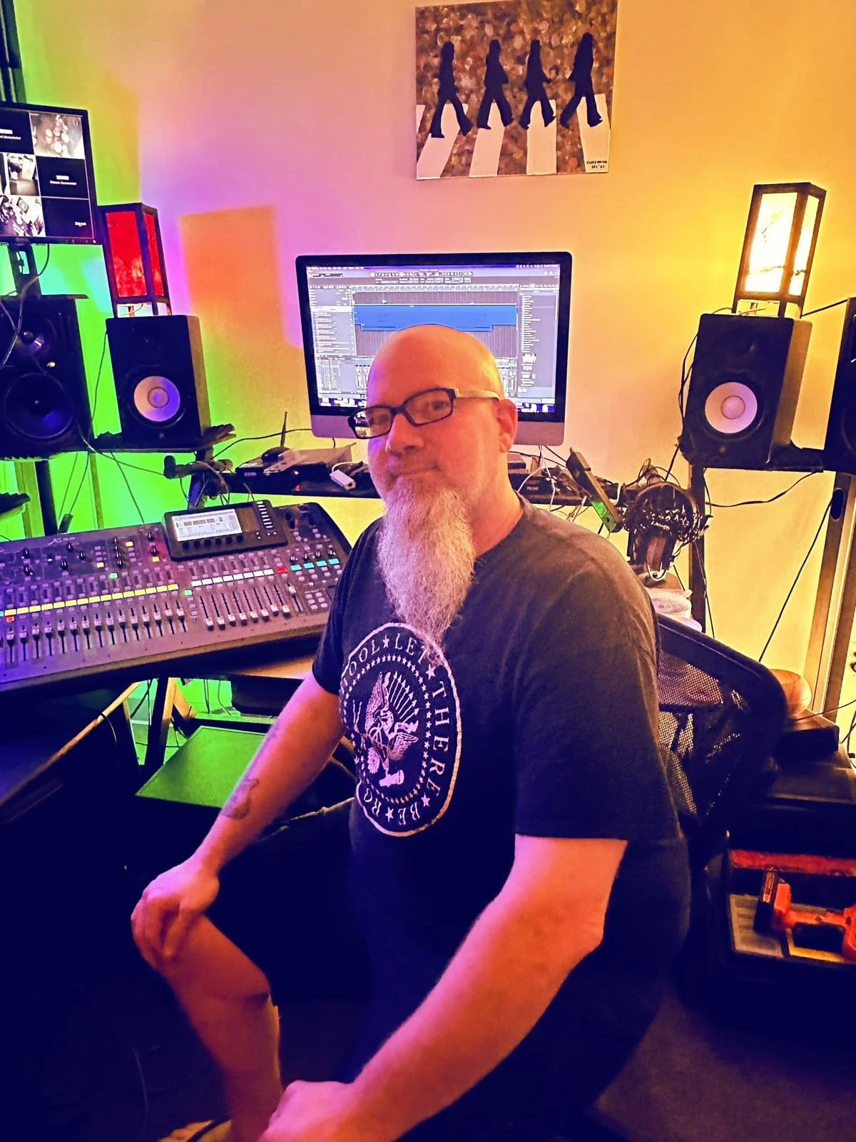 Jeremy Whiteley, founder of Let There Be Rock School Fountain Valley, seated at the mixing console in the school's recording studio
